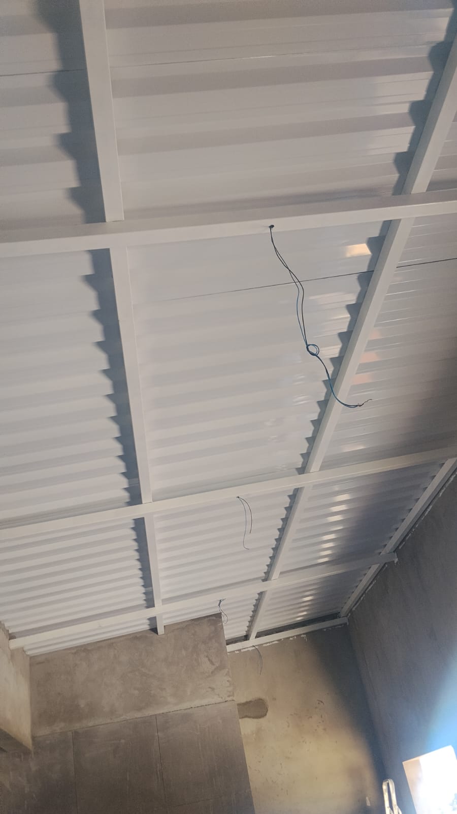 Estrutura metálica pintada de branco com telhas trapezoidais
