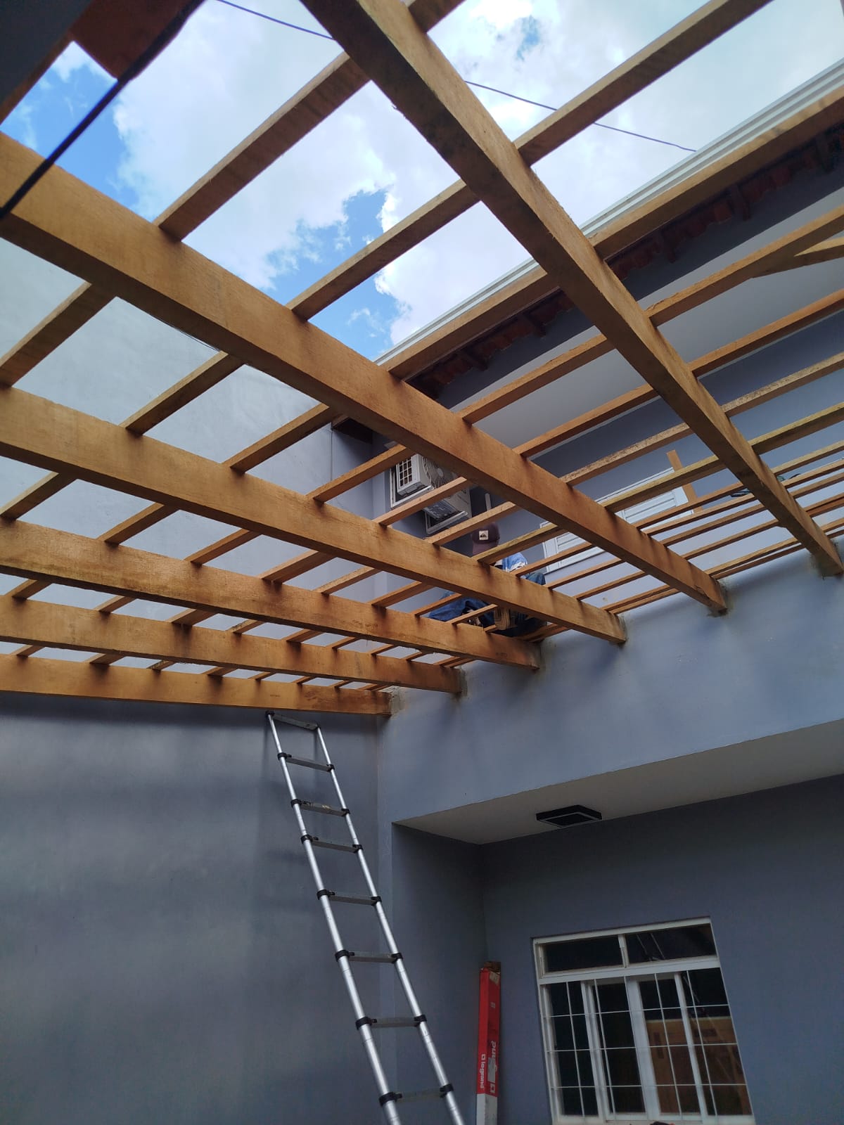 Construção de estrutura de madeira para cobertura de área externa