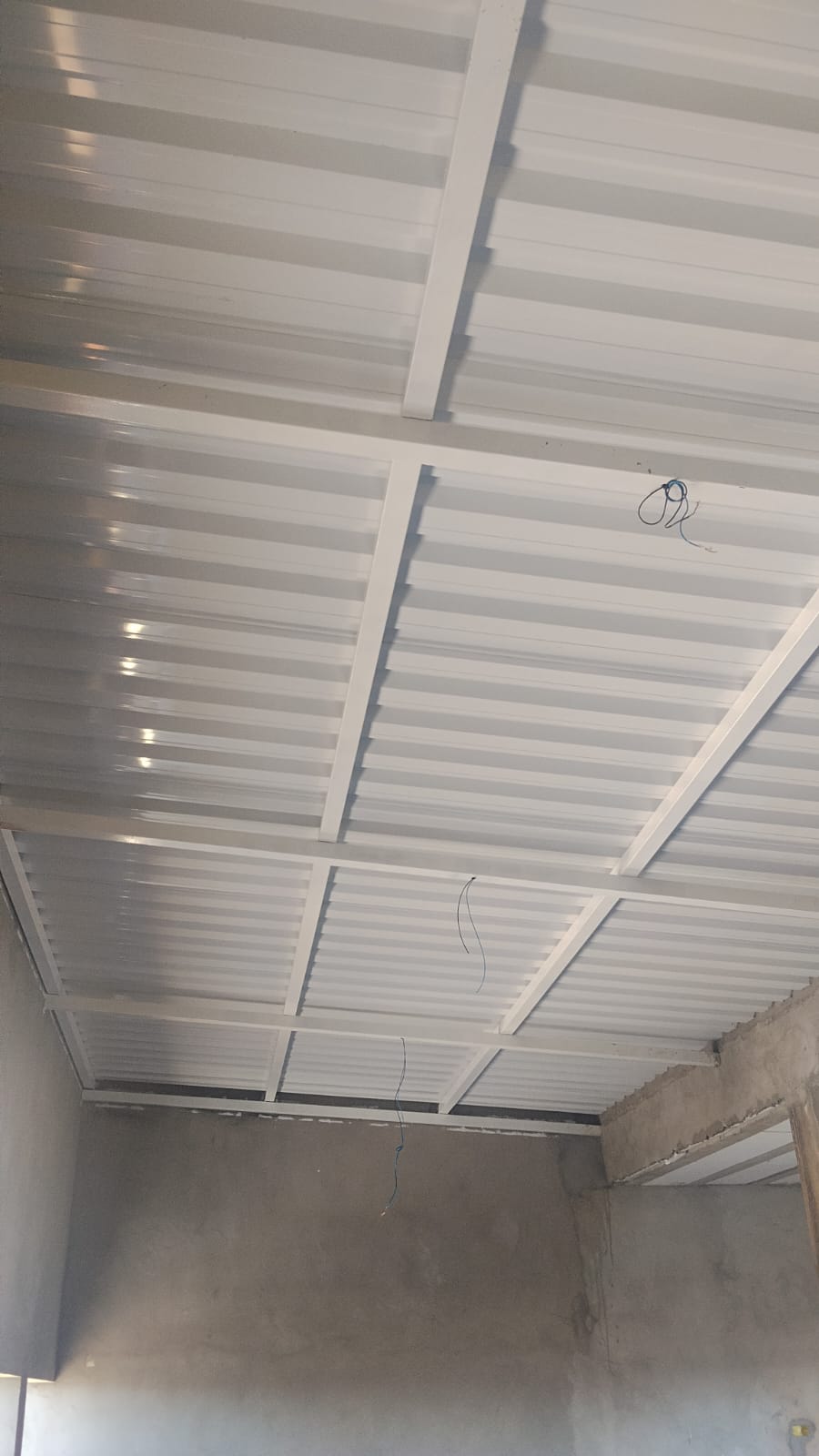 Cobertura metálica termoacústica branca instalada em laje residencial