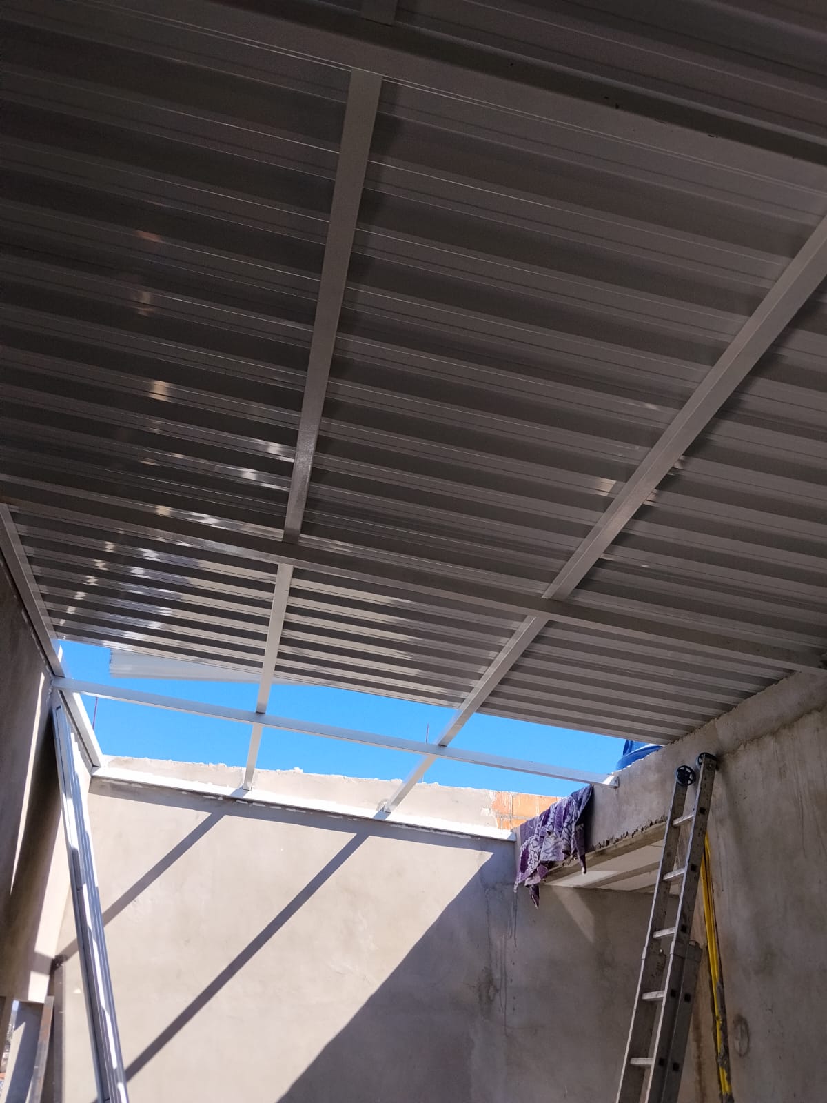 Cobertura metálica trapezoidal instalada com estrutura branca