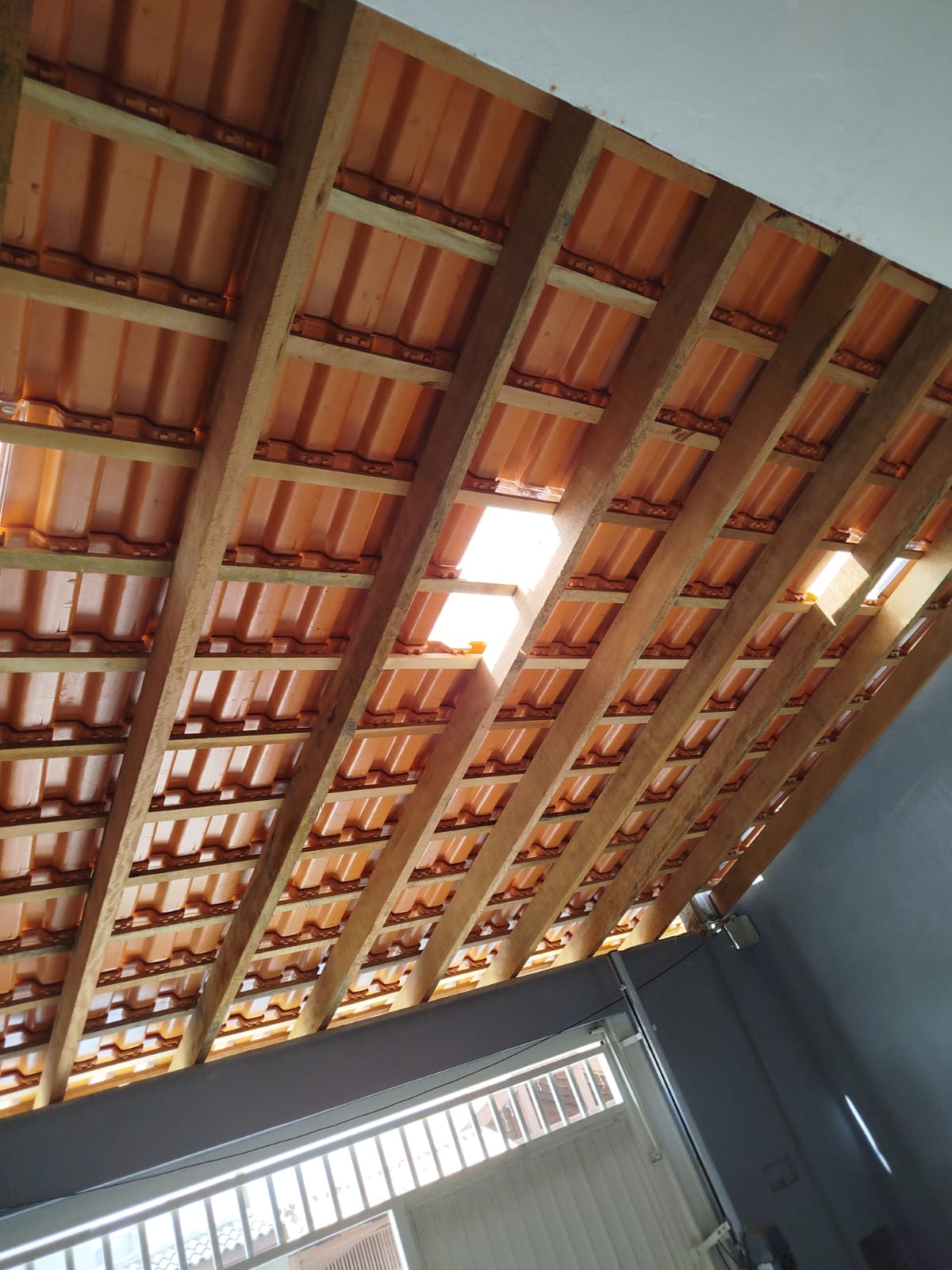 Detalhe interno de telhado cerâmico com estrutura de madeira
