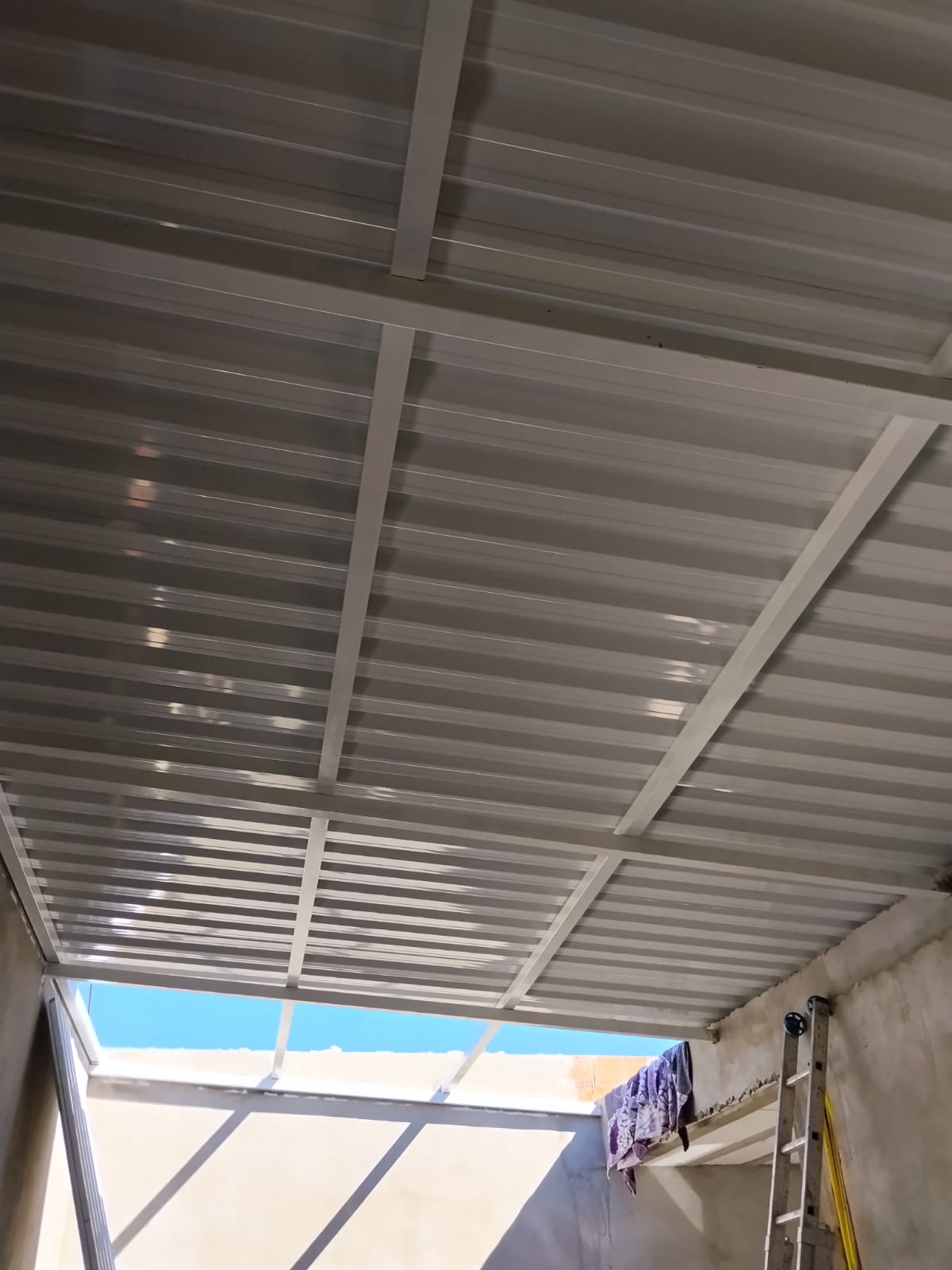Detalhe da fixação de telhas metálicas em estrutura branca