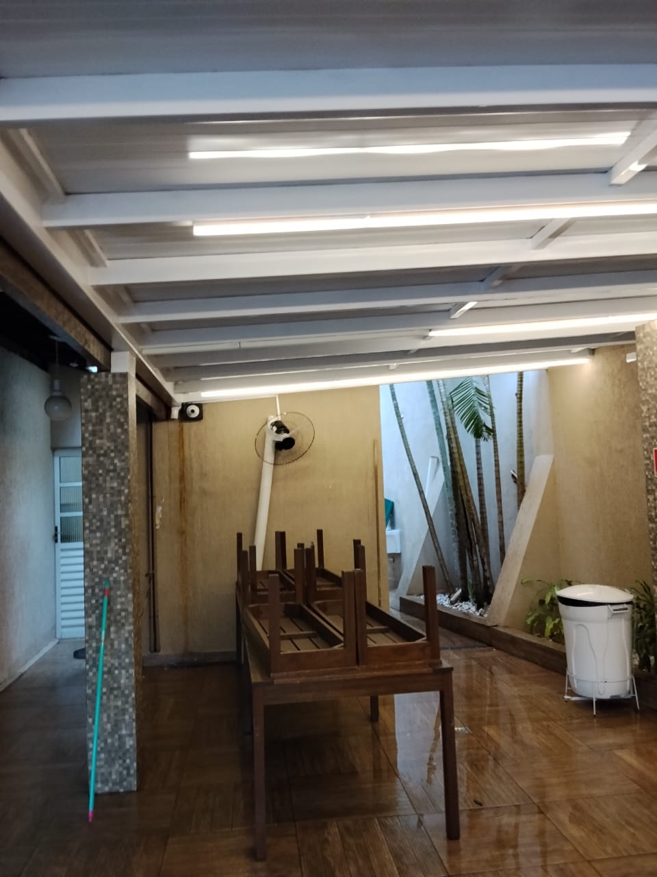 Cobertura metálica com iluminação LED em varanda residencial