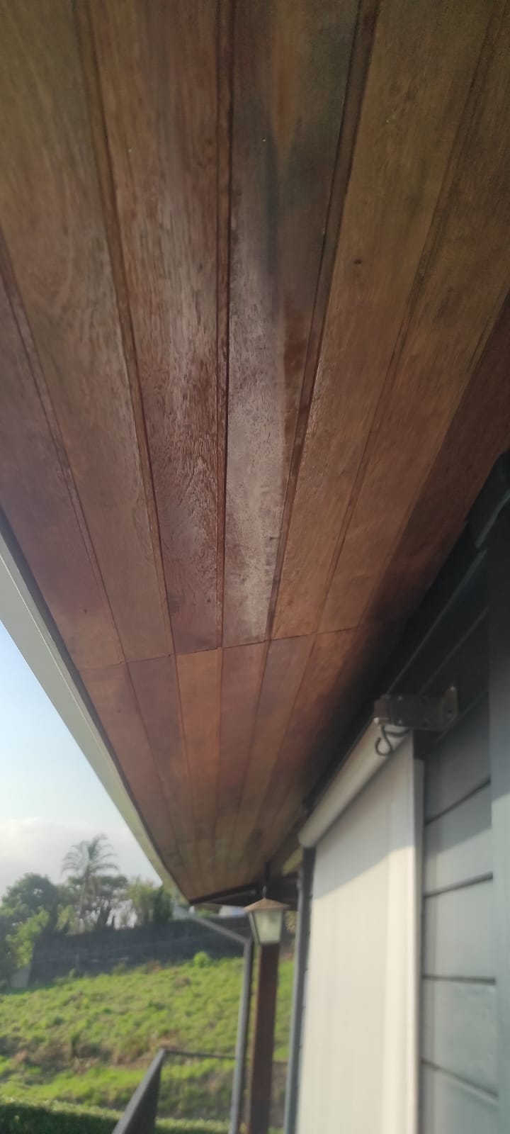 Detalhe de forro de madeira maciça sob beiral residencial