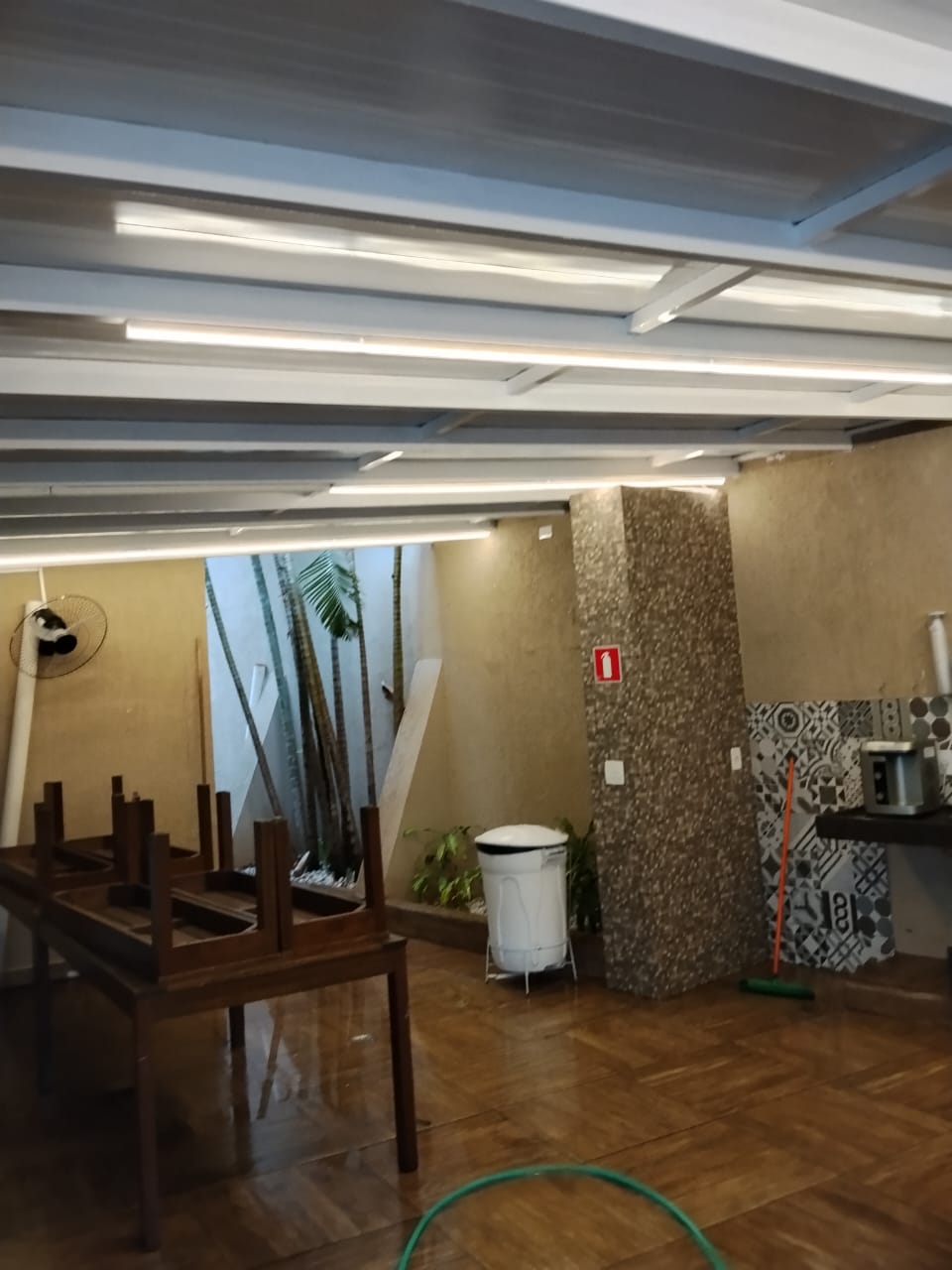 Área de churrasqueira com cobertura metálica e iluminação embutida