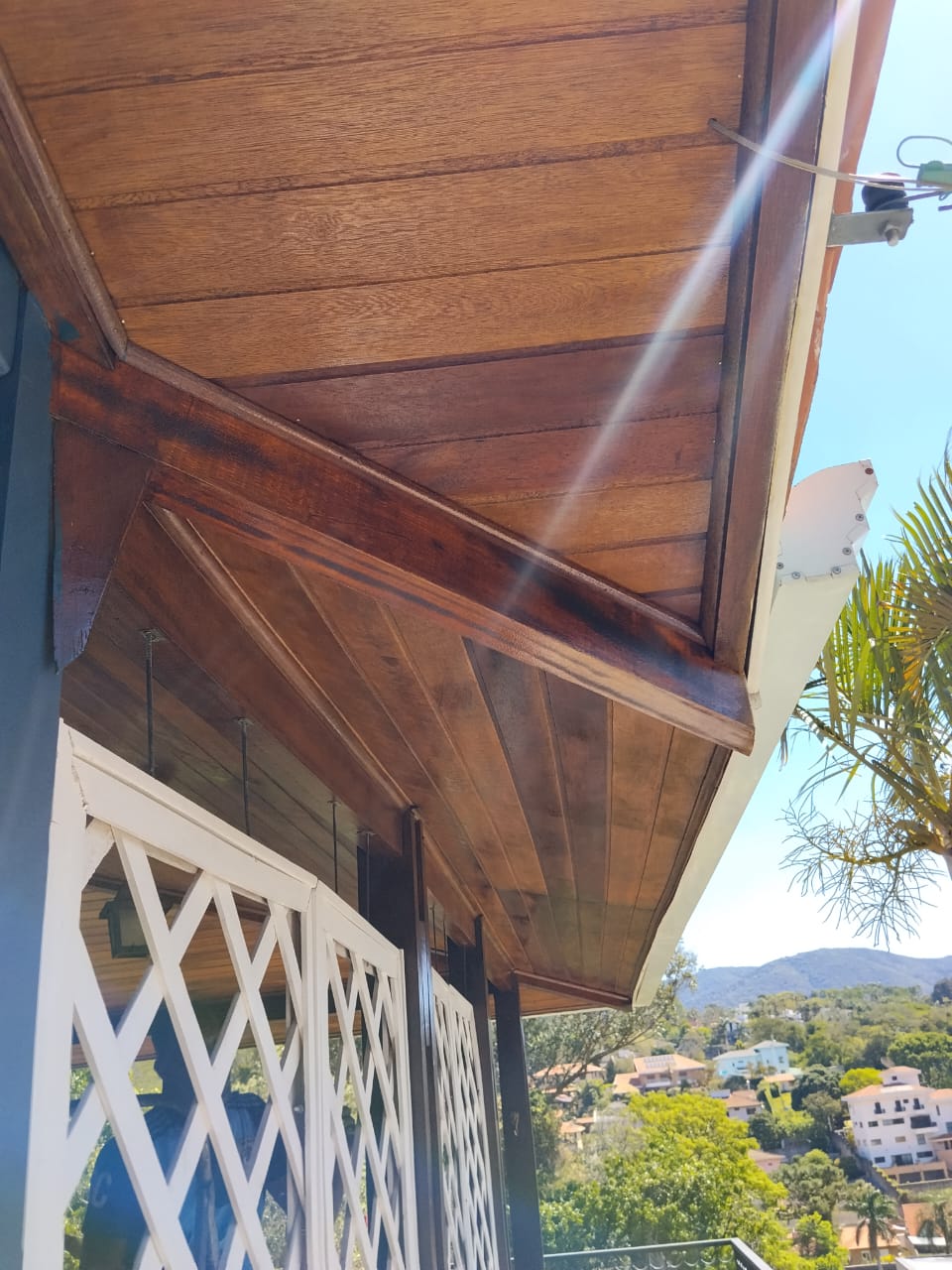 Detalhe premium de forro de madeira maciça em beiral residencial